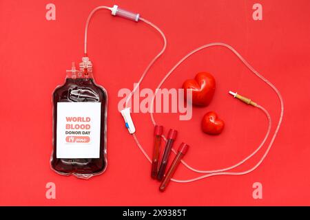 Zusammensetzung mit Blutpackung zur Transfusion mit Text WELTBLUTSPENDERTAG 14. JUNI, Herzen und Reagenzgläser auf rotem Hintergrund Stockfoto