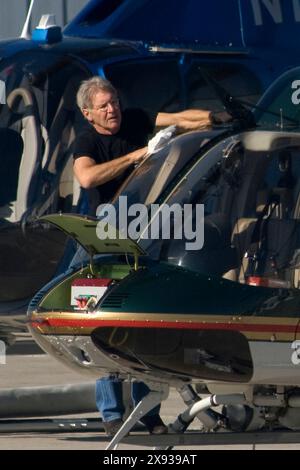 EXKLUSIV. Harrison Ford überprüft und reinigt die Fenster seines Hubschraubers, bevor er in Santa Monica, Kalifornien, fliegt. Stockfoto