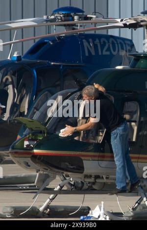 EXKLUSIV. Harrison Ford überprüft und reinigt die Fenster seines Hubschraubers, bevor er in Santa Monica, Kalifornien, fliegt. Stockfoto