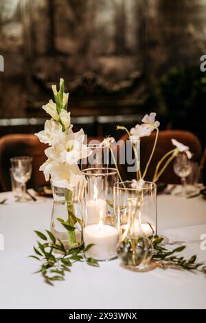 Luxuriöse Hochzeitseinrichtung. Gläser, Kerzen und Blumen. Platz für Gäste. Hochwertige Fotos Stockfoto