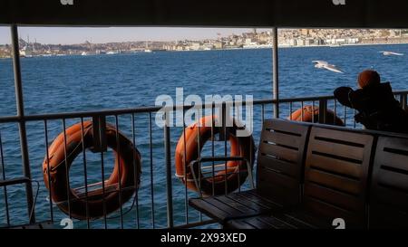 Rückansicht einer Person, die mit dem Fährschiff auf dem Bosporus reist. Istanbul, Türkei. Möwen auf dem Hintergrund. Reise- und Urlaubskonzept. Hochwertige Fotos Stockfoto