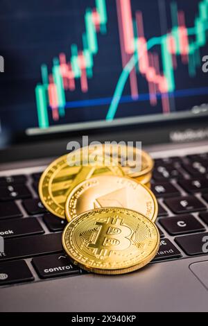 Bitcoin, litecoin und ethereum. Kryptowährung auf dem Computer Tastatur und Geschäftsdiagramm auf dem Bildschirm im Hintergrund. Stockfoto