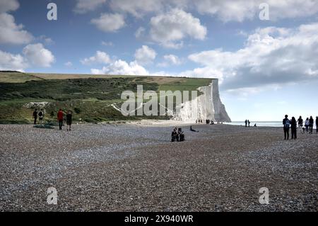 Cuckmere Haven, Großbritannien - 10. September 2022: Blick auf die Seven Sisters Cliffs an sonnigem Tag mit Wolken, die Klippen zeigen, Fußweg mit Spaziergängern und zahlreichen Peop Stockfoto