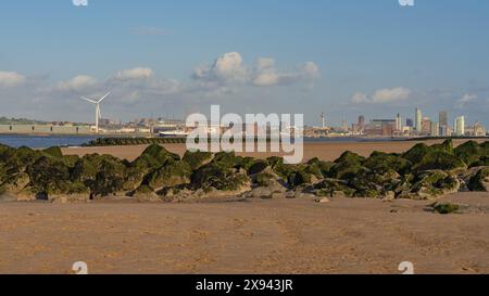 New Brighton, Merseyside, England, Großbritannien - 16. Mai 2023: Die Skyline von Liverpool, vom Strand aus gesehen, mit der Hochgeschwindigkeits-Katamaran-Fähre zur Isle o Stockfoto