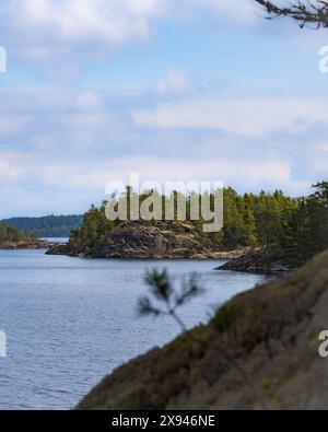 Eine malerische Aussicht auf einen ruhigen See, umgeben von üppigem Grün und felsigen Ufern, die die natürliche Schönheit einfangen. Stockfoto