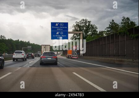 Ein Baustellenfahrzeug auf der Autobahn mit einem Schild, das eine Geschwindigkeitsbegrenzung anzeigt Stockfoto