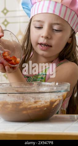 Ein Mädchen, verkleidet als Koch, genießt einen Nachmittag mit ihrer Mutter Stockfoto