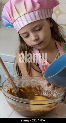 Ein Mädchen, verkleidet als Koch, genießt einen Nachmittag mit ihrer Mutter Stockfoto