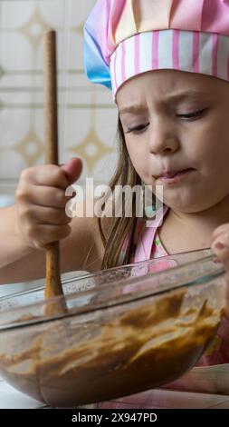 Ein Mädchen, verkleidet als Koch, genießt einen Nachmittag mit ihrer Mutter Stockfoto