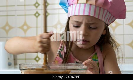 Ein Mädchen, verkleidet als Koch, genießt einen Nachmittag mit ihrer Mutter Stockfoto