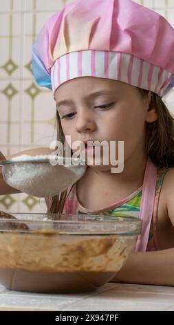 Ein Mädchen, verkleidet als Koch, genießt einen Nachmittag mit ihrer Mutter Stockfoto