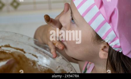 Ein Mädchen, verkleidet als Koch, genießt einen Nachmittag mit ihrer Mutter Stockfoto