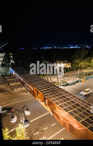 Baku, Aserbaidschan - 3. Mai 2019: Nächtlicher Blick auf ein Werbebanner für Konzerte von Sam Smith und Cardi B auf einer Brücke in Baku, mit verschwommenen Autos, die unten vorbeifahren und Stadtlichtern im Hintergrund sichtbar sind Stockfoto