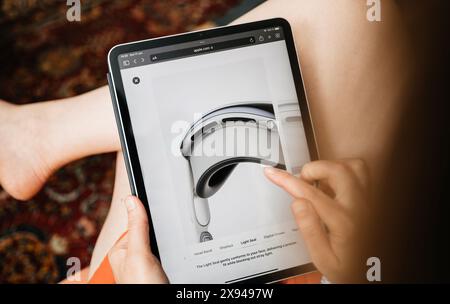 Paris, Frankreich – 11. Juni 2023: Eine Frau durchsucht auf einem iPad eine Apple-Website und konzentriert sich dabei auf die Details eines Vision Pro Headsets. Ihr Finger zeigt auf die Beschreibung des Light Seal auf dem Bildschirm Stockfoto