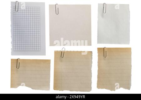 Satz alter Fetzen verschiedener Papiersorten mit abgerissenen Kanten, die mit einer Büroklammer auf weißem Hintergrund fixiert sind. Stockfoto