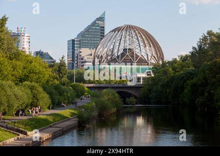 Jekaterinburg, Russland - 15. Juli 2018: Menschen, die entlang des Flusses Iset mit hinter dem Jekaterinburg Circus spazieren. Stockfoto