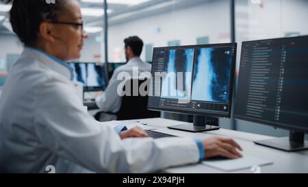 Modernes Krankenhauslabor: Schwarze weibliche Ärztin arbeitet an Computer Analyse Brust, Knochen Röntgenstrahlen auf dem Bildschirm. Professioneller Afroamerikanischer Arzt, Der High-Tech-Behandlungsforschung Betreibt Stockfoto