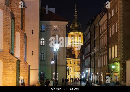 Flache Gebäude mit vorbeiziehender Menschenmenge in der Nähe des Schlossplatzes (Plac Zamkowy), der historischen Straße Swietojanska bei Nacht, der Altstadt, Warschau, Polen, Europa Stockfoto