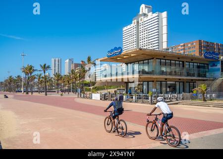 Blick auf Radfahrer, Cafés und Hotels an der Promenade, Durban, Provinz KwaZulu-Natal, Südafrika, Afrika Stockfoto