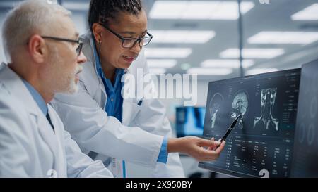 Medizinisches Krankenhaus: Neurologe und Neurochirurg sprechen, Computer verwenden, Patient MRT-Scan analysieren, Gehirn diagnostizieren. Health Clinic Lab: Zwei Fachärzte schauen auf funktionelle CT-Scans, Behandlung finden Stockfoto
