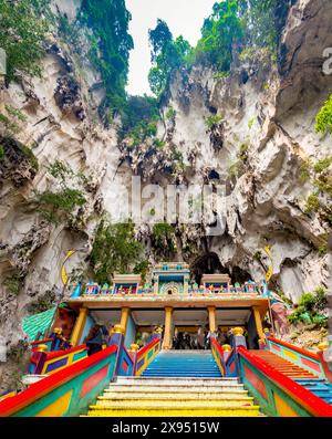 Innerhalb der Kalksteinberge, die Kuala Lumpur Stadt umgeben, führen viele bunte Stufen hinauf zu der riesigen Höhle, in der sich wunderschöne Hindutempel und Schrein befinden Stockfoto