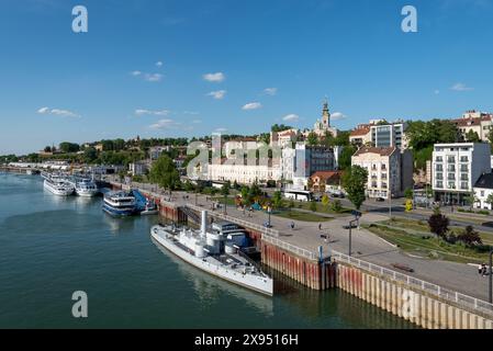 Skyline von Belgrad mit Kreuzfahrtschiffen, dem Monitor Sava, alten Gebäuden und dem Turm der Kathedrale Kirche St. Michael dem Erzengel. April 2024. Stockfoto