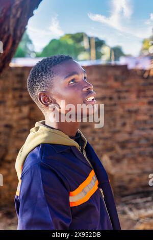 Porträt eines einzelnen afroamerikanischen Mannes, der draußen Arbeitskleidung trägt Stockfoto