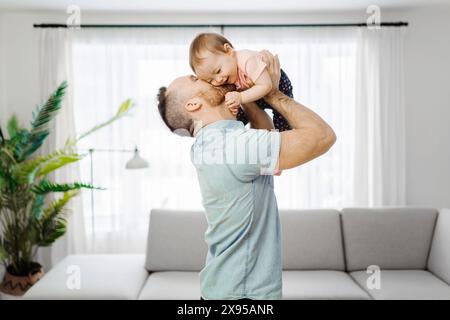 Vater mit seiner kleinen Tochter, die im Wohnzimmer lustig war Stockfoto