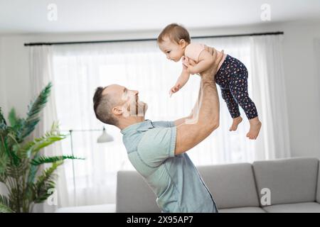 Vater mit seiner kleinen Tochter, die im Wohnzimmer lustig war Stockfoto