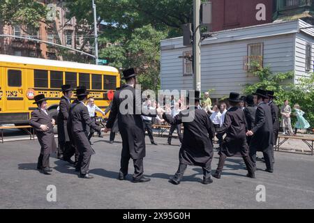 Chassidische Lehrer und ältere Schüler tanzen den lag B'Omer-Feiertag. In Williamsburg, Brooklyn, New York, 2024. Stockfoto