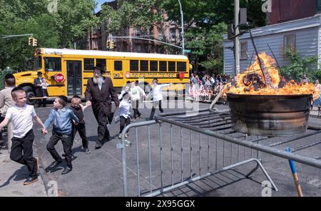 Während einer lag B'Omer-Feier tanzen Yeshiva-Jungs und ihre Rabbiner am traditionellen Festfeuer. In Brooklyn, New York. Stockfoto