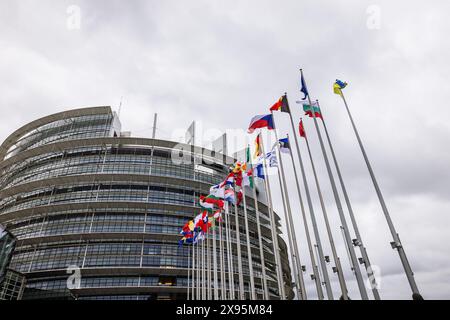 29. Mai 2024, Frankreich, Straßburg: Die Flaggen der Europäischen Union, ihrer Mitgliedstaaten und der Ukraine fliegen vor dem Gebäude des Europäischen Parlaments. Beamte durchsuchen seit heute Morgen die Büros des Parlaments in Brüssel und Straßburg. Die Überfälle stehen offenbar im Zusammenhang mit der Affäre um das prorussische Nachrichtenportal "Voice of Europe", das angeblich im Zentrum einer russischen Einflussoperation steht. Die Europawahlen sind für den 9. Juni vorgesehen. Foto: Philipp von Ditfurth/dpa Stockfoto