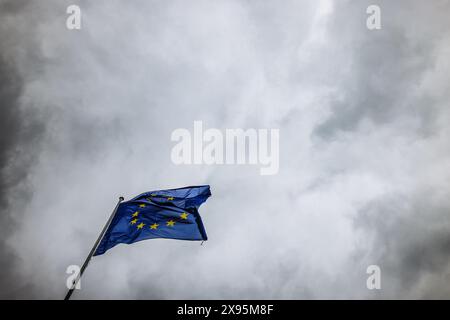 29. Mai 2024, Frankreich, Straßburg: Die Flagge der Europäischen Union fliegt im Wind vor dem Gebäude des Europäischen Parlaments. Beamte durchsuchen seit heute Morgen die Büros des Parlaments in Brüssel und Straßburg. Die Überfälle stehen offenbar im Zusammenhang mit der Affäre um das prorussische Nachrichtenportal "Voice of Europe", das angeblich im Zentrum einer russischen Einflussoperation steht. Die Europawahlen sind für den 9. Juni vorgesehen. Foto: Philipp von Ditfurth/dpa Stockfoto