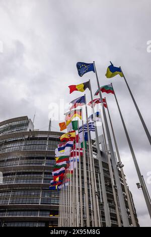 29. Mai 2024, Frankreich, Straßburg: Die Flaggen der Europäischen Union, ihrer Mitgliedstaaten und der Ukraine fliegen vor dem Gebäude des Europäischen Parlaments. Beamte durchsuchen seit heute Morgen die Büros des Parlaments in Brüssel und Straßburg. Die Überfälle stehen offenbar im Zusammenhang mit der Affäre um das prorussische Nachrichtenportal "Voice of Europe", das angeblich im Zentrum einer russischen Einflussoperation steht. Die Europawahlen sind für den 9. Juni vorgesehen. Foto: Philipp von Ditfurth/dpa Stockfoto