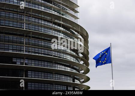 29. Mai 2024, Frankreich, Straßburg: Die Flagge der Europäischen Union fliegt im Wind vor dem Gebäude des Europäischen Parlaments. Beamte durchsuchen seit heute Morgen die Büros des Parlaments in Brüssel und Straßburg. Die Überfälle stehen offenbar im Zusammenhang mit der Affäre um das prorussische Nachrichtenportal "Voice of Europe", das angeblich im Zentrum einer russischen Einflussoperation steht. Die Europawahlen sind für den 9. Juni vorgesehen. Foto: Philipp von Ditfurth/dpa Stockfoto