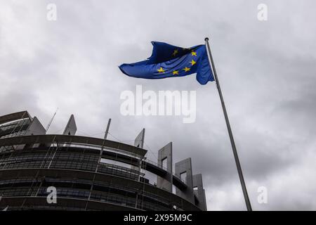 29. Mai 2024, Frankreich, Straßburg: Die Flagge der Europäischen Union fliegt im Wind vor dem Gebäude des Europäischen Parlaments. Beamte durchsuchen seit heute Morgen die Büros des Parlaments in Brüssel und Straßburg. Die Überfälle stehen offenbar im Zusammenhang mit der Affäre um das prorussische Nachrichtenportal "Voice of Europe", das angeblich im Zentrum einer russischen Einflussoperation steht. Die Europawahlen sind für den 9. Juni vorgesehen. Foto: Philipp von Ditfurth/dpa Stockfoto