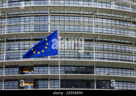 29. Mai 2024, Frankreich, Straßburg: Die Flagge der Europäischen Union fliegt im Wind vor dem Gebäude des Europäischen Parlaments. Beamte durchsuchen seit heute Morgen die Büros des Parlaments in Brüssel und Straßburg. Die Überfälle stehen offenbar im Zusammenhang mit der Affäre um das prorussische Nachrichtenportal "Voice of Europe", das angeblich im Zentrum einer russischen Einflussoperation steht. Die Europawahlen sind für den 9. Juni vorgesehen. Foto: Philipp von Ditfurth/dpa Stockfoto