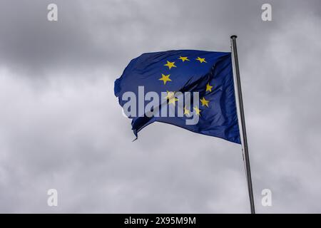 29. Mai 2024, Frankreich, Straßburg: Die Flagge der Europäischen Union fliegt im Wind vor dem Gebäude des Europäischen Parlaments. Beamte durchsuchen seit heute Morgen die Büros des Parlaments in Brüssel und Straßburg. Die Überfälle stehen offenbar im Zusammenhang mit der Affäre um das prorussische Nachrichtenportal "Voice of Europe", das angeblich im Zentrum einer russischen Einflussoperation steht. Die Europawahlen sind für den 9. Juni vorgesehen. Foto: Philipp von Ditfurth/dpa Stockfoto