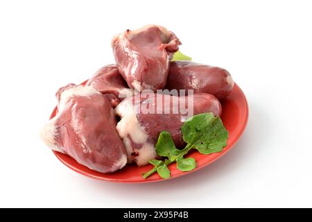 Mehrere truthahnherzen, bereit zum Kochen, sitzen in einem Haufen auf einem Teller. Stockfoto