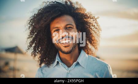 Porträt eines glücklichen jungen Erwachsenen männlich mit Afro-Haar- und Nasenring-Piercing posiert für die Kamera. Hübsche, Vielseitige, Multiethnische Schwarze, Die Lächelnd Sind. Warme Farbbearbeitung. Stockfoto
