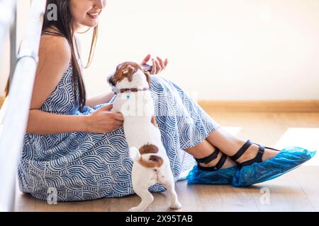 Glückliches Mädchen beim Yoga mit dem kleinen Jack Russell Terrier Welpen. Gesunder Lebensstil und Meditation Stockfoto