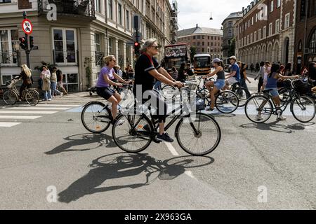 Kopenhagen, Dänemark. Mai 2024. Die Menschen fahren mit dem Fahrrad in der Gegend von Nyhavn, im Zentrum von Kopenhagen. Kopenhagen belegt bei der Mercer Quality of Living Survey 2023 weltweit den vierten Platz. Eine stabile Wirtschaft, ausgezeichnete Bildungsangebote und hohe soziale Sicherheit machen es für Einheimische und Touristen attraktiv. Kopenhagen ist auch eine der teuersten Städte der Welt und ein beliebtes Touristenziel. Quelle: SOPA Images Limited/Alamy Live News Stockfoto