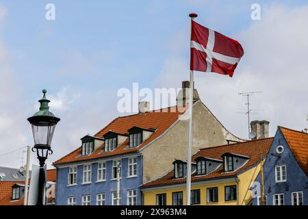 Kopenhagen, Dänemark. Mai 2024. Die Flagge Dänemarks ist in der Nähe des Kanals in Nyhavn zu sehen, gedreht im Zentrum von Kopenhagen. Kopenhagen belegt bei der Mercer Quality of Living Survey 2023 weltweit den vierten Platz. Eine stabile Wirtschaft, ausgezeichnete Bildungsangebote und hohe soziale Sicherheit machen es für Einheimische und Touristen attraktiv. Kopenhagen ist auch eine der teuersten Städte der Welt und ein beliebtes Touristenziel. Quelle: SOPA Images Limited/Alamy Live News Stockfoto