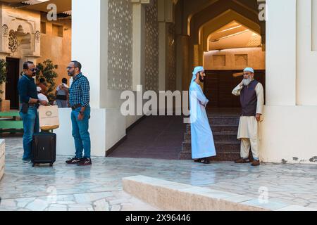 Old Town Dubai, VAE - 6. Januar 2024: Einheimische unterhalten sich, während andere ihren Tag im historischen Viertel verbringen. Stockfoto