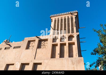 Dubai, VAE - 6. Januar 2024: Traditionelle Windtürme und Architektur im historischen Viertel Al Fahidi unter klarem blauem Himmel. Stockfoto