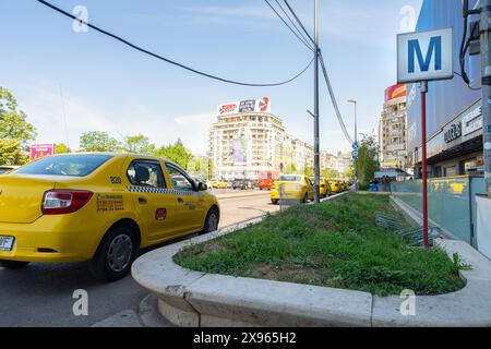 Bucarest, Rumänien. Mai 2024. Blick auf das Schild mit der U-Bahn-Station und einige Taxis auf der Straße in einem Treet des Stadtzentrums Stockfoto