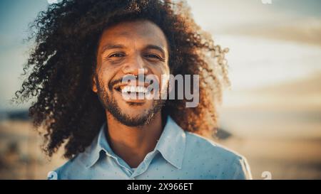 Porträt eines glücklichen jungen Erwachsenen männlich mit Afro-Haar- und Nasenring-Piercing posiert für die Kamera. Hübsche, Vielseitige, Multiethnische Schwarze, Die Lächelnd Sind. Warme Farbbearbeitung. Stockfoto