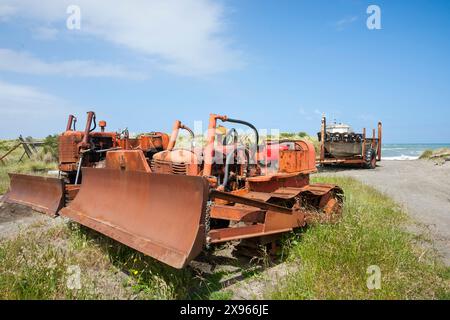 Alte Bulldozer schleppten früher Boote zum Wasser und zurück in die Dünen an der Wairarapa-Küste bei Tora. Stockfoto