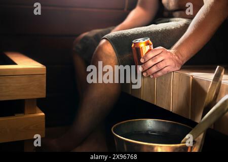 Sauna und Bier. Mann im Dampfbad entspannt und trinkt etwas. Traditionelles finnisches Wellnesszentrum aus dunklem Holz oder im Wellness-Hotel in Finnland. Stockfoto