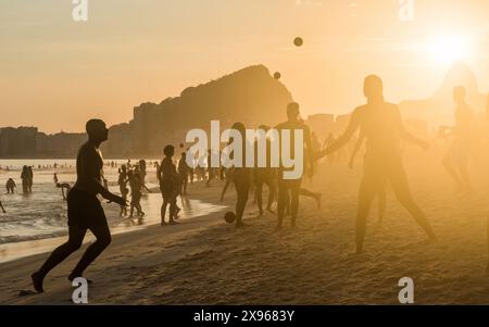 Menschen, die sich bei Sonnenuntergang entspannen und sich bei Sonnenuntergang amüsieren, Copacabana Beach, Rio de Janeiro, Brasilien, Südamerika Stockfoto